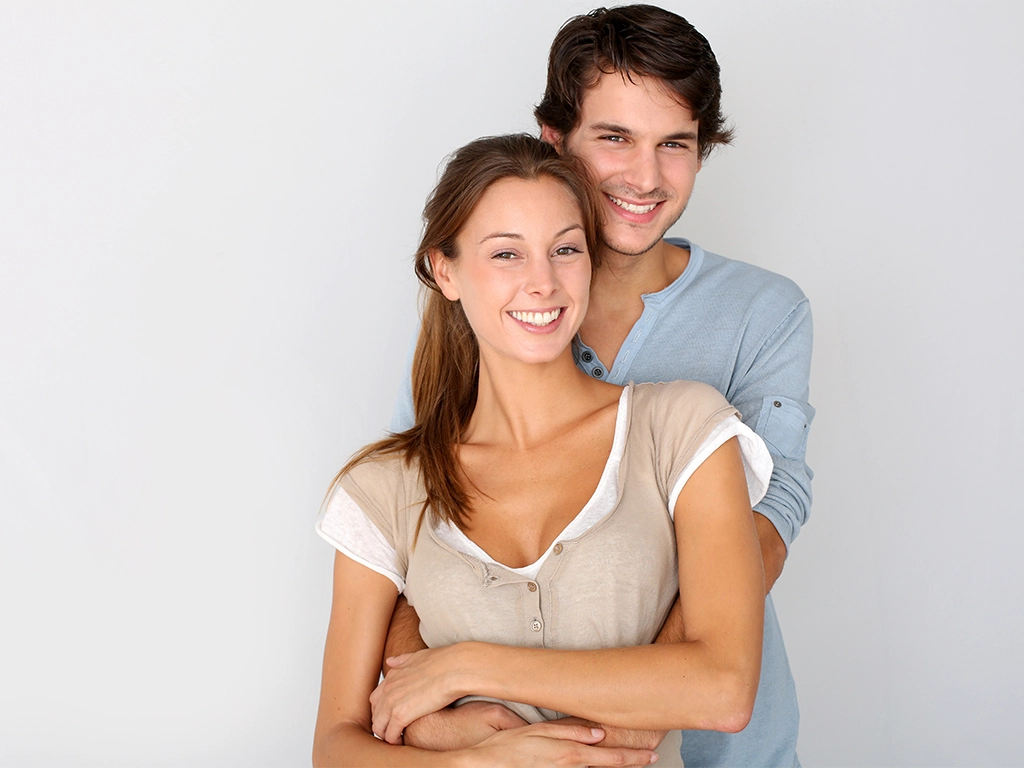 Young couple with bright smiles highlighting cosmetic dentistry
